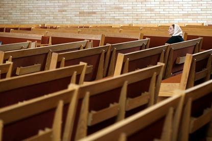 2020-12-28T153559Z_2017590297_MT1USATODAY15367760_RTRMADP_3_A-LONE-PARISHIONER-SITS-IN-THE-PEWS-DURING-GOOD-FRIDAY-MASS
